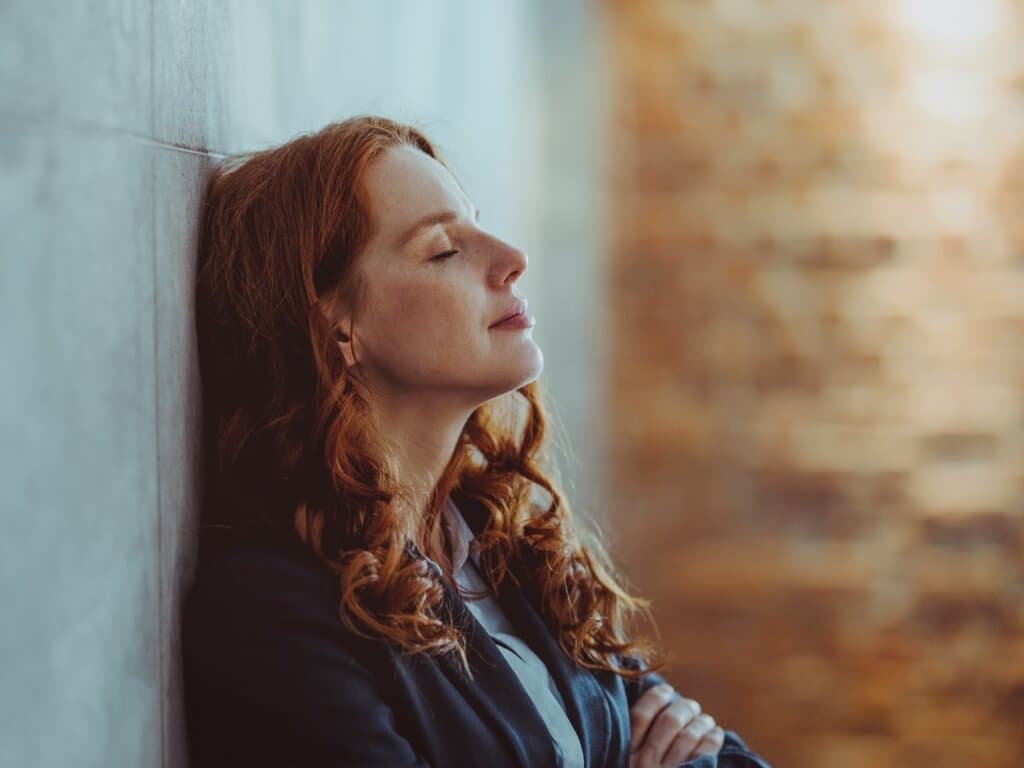 Žena se zavřenýma očima přemýšlí o svých finančních možnostech